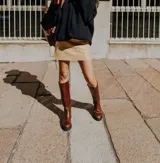 Botas de caña alta hasta la rodilla, confeccionadas en cuero, con suela track de goma y cierre frontal con cremallera.