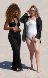 Traje de baño enterizo blanco con breteles finos y abertura en el pecho.