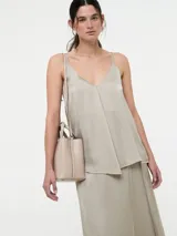 Top de viscosa con escote en V y breteles finos regulables. Presenta un diseño minimalista con caída fluida y acabado satinado.