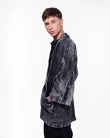 Kimono negro con efecto lavado, confeccionado en algodón. Tiene corte amplio, mangas 3/4, bolsillos laterales y cierre frontal con hebilla metálica.