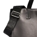 Cartera tipo tote de cuero negro con diseño estructurado, doble asa de hombro y correa larga ajustable con logo grabado. Presenta el logo metálico XL en la parte frontal.