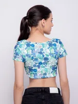 Crop top de punto color verde claro con estampado a cuadros blancos, escote redondo y mangas cortas.