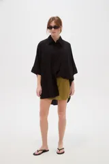 Camisa de lino blanca de corte holgado, con cuello camisero y mangas tres cuartos, diseñada con estilo casual.