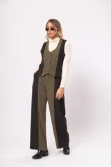 Pantalón de tiro alto con bolsillos delanteros y traseros, cierre frontal con cremallera y botón. Diseño a bloques en negro y verde.