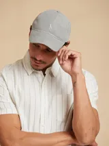 Gorro tipo visera de algodón color gris, con logo bordado en el frente.