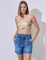 Short blanco de tencel, con pretina ancha elastizada y lazo de ajuste. Presenta bolsillos verticales en la parte delantera.