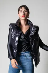 Chaleco negro puffer con cuello alto y cierre frontal con cremallera.