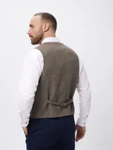 Chaleco sastrero de corte regular fit con diseño de espiga, escote en V y cierre frontal de botones. Cuenta con bolsillos frontales tipo ojal.