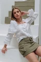 Minifalda cargo de denim azul oscuro con costuras pespuntadas y grandes bolsillos laterales con solapa y botones a presión.