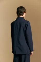 Blazer de corte sastrero con solapas clásicas y estructura definida. Presenta un diseño versátil con silueta ligeramente oversized, ideal para un estilo sofisticado y atemporal.