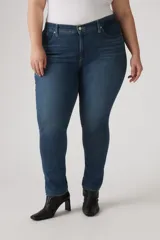 Pantalón de jean azul oscuro, tiro medio, corte ajustado y largo hasta el tobillo.