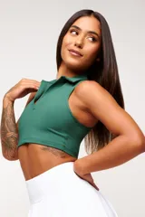 Top deportivo negro, estilo crop top, con cuello polo y escote en V. Presenta tirantes anchos y corte ajustado al cuerpo.