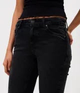 Pantalón jeans estilo bootcut de tiro bajo, con diseño clásico de cinco bolsillos, trabillas para cinturón y cierre frontal con botón y cremallera.