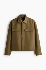 Sobrecamisa boxy de algodón, color verde militar, con cuello inglés, tapeta con botones a presión y bolsillos superiores con solapa.