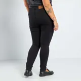 Pantalón de jean skinny negro con tiro alto y cierre frontal con botones.