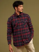 Camisa a cuadros azul y roja de manga larga con dos bolsillos frontales con botón.
