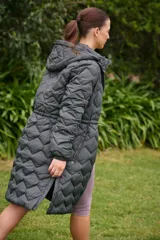 Campera larga color marrón con diseño acolchado, capucha desmontable, cierre frontal con botones a presión, bolsillos laterales con cierre, puños elásticos y cintura ajustable.