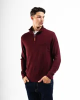 Buzo de tejido de punto color bordó, con cuello alto y cierre frontal parcial con tirador de cuero. Presenta puños y ruedo acanalados.