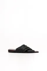 Sandalias chatas de cuero negro con tiras cruzadas y plisadas, y plantilla en tono bordó con punta cuadrada.