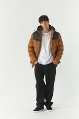 Campera puffer marrón con capucha y detalles en negro. Cierre frontal con cremallera, bolsillos laterales con cierre y puños elásticos.