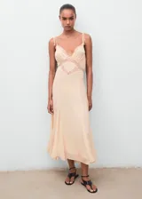 Vestido midi de estilo lencero color salmón, con detalles de encaje en el escote en pico y bajo el busto. Cuenta con tirantes finos ajustables, diseño evasé y forro interior.