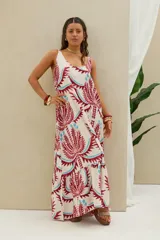 Vestido largo de tirantes en color blanco con estampado geométrico y floral en tonos bordó y celeste, corte amplio y volados en el ruedo.