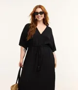 Vestido midi de jacquard color negro, con escote en V y cordón ajustable en la cintura. Presenta mangas cortas de estilo holgado y una textura sutil en el tejido de viscosa.