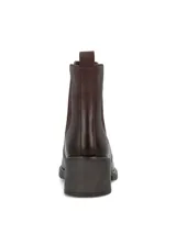 Botín de cuero marrón oscuro, con paneles elásticos laterales y detalles de tachas metálicas doradas a lo largo de las costuras. Cuenta con taco bloque y suela track.