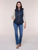Chaleco acolchado de diseño entallado color beige, con matelaseado en patrón de rombos en frente y espalda, cuello alto estructurado y cierre frontal completo con cremallera metálica y ribete a contraste.