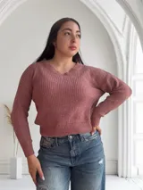 Sweater de chenille color rosa, con escote en V y mangas largas. Tejido de punto grueso.