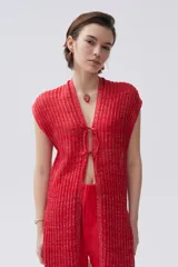 Kimono tejido de punto con destellos de lurex, color rojo, sin mangas, con cierre frontal mediante lazos y diseño largo.