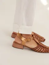 Pantalon de corte cigarette confeccionado en lino, de tiro medio con cierre frontal de boton y bolsillos delanteros tipo parche. Presenta un diseño estructurado con dobladillo en los tobillos.