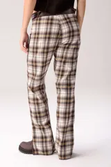 Pantalón de corte acampanado con diseño combinado. Presenta un estampado de cuadros tartán en tonos marrones, blancos y amarillos, con paneles laterales y bolsillos delanteros en cuero marrón oscuro.