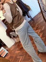 Chaleco marrón de tela agamuzada con apliques cortados y bordados a mano. Diseño sin mangas con cuello en V.