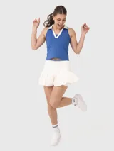 Top deportivo sin mangas con cuello polo y escote en V, diseñado con tecnología de secado rápido. Presenta un diseño bicolor en azul y blanco con detalles de rayas en el cuello.