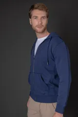 Campera con capucha y cierre frontal, confeccionada en algodón de color azul. Presenta bolsillos tipo canguro, puños y ruedo acanalados.