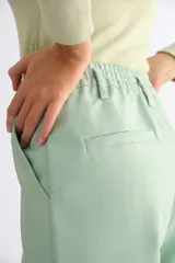 Pantalón de cuerina color marrón, de corte recto, con pretina elastizada y pasacinto.