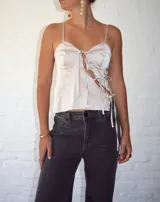 Top color champagne de seda con breteles finos, escote con frunce y lazos decorativos.