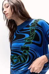 Sweater tejido de punto color azul con diseño marmoleado en negro y aplique bordado con contorno verde.