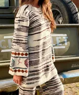 Vestido midi de lana merino tejido a mano, de color blanco con líneas horizontales marrones, mangas oxford y detalles bordados a mano en los puños.
