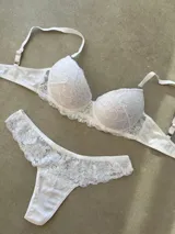 Conjunto de lencería compuesto por un corpiño taza soft con detalles de puntilla y una bombacha tipo less con laterales de encaje.