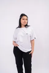 Remerón blanco de corte amplio y relajado, con hombros caídos, mangas cortas amplias y pequeño detalle estampado en el pecho.