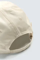Gorra de seis paneles, color beige, con visera azul marino. Presenta bordado frontal con el texto "Genuine Ford Parts" en tonos azul y rojo, y un pequeño parche bordado con el logo de Ford en el lateral.