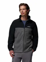 Campera polar de Columbia con cierre frontal completo, cuello alto y diseño de bloques de color en negro y gris. Cuenta con bolsillos laterales con cierre y logo de la marca bordado en el pecho.