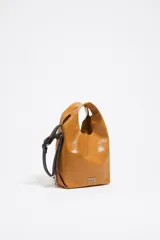 Bolso tipo bandolera y de mano Bimba y Lola modelo Paper Mini, de cuero color marrón con acabado brillante. Cuenta con asas superiores integradas, correa ajustable y desmontable, y el logo de la marca impreso en metal plateado en la parte inferior frontal.