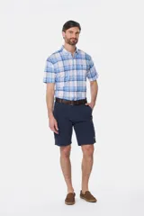 Bermuda cargo color beige con bolsillos laterales y traseros. Se ajusta a la cintura con cinturón de cuero marrón.