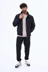 Campera de nylon color negro con cierre frontal, puños y ruedo elásticos, y cuello con forro de corderito sintético.