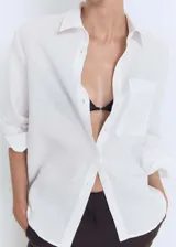 Camisa de lino blanca con cuello camisero, cierre frontal de botones, manga larga y bolsillo aplicado en el pecho.