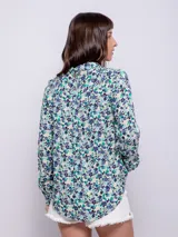 Camisa estampada azul con lunares blancos y rosados, de corte holgado y manga larga con puños abotonados.