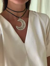 Gargantilla de cuero sintético negro con dije de luna plateada calada.